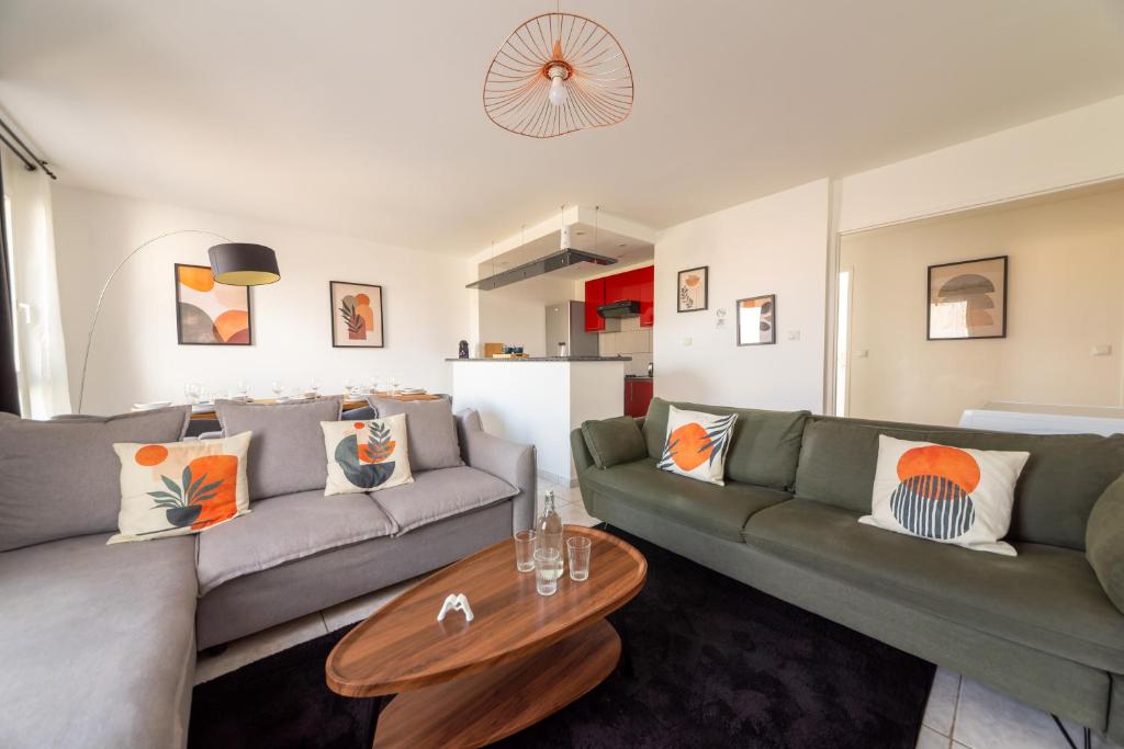 a living room with a couch and a table at Warm cocoon - parking included in Asnières-sur-Seine