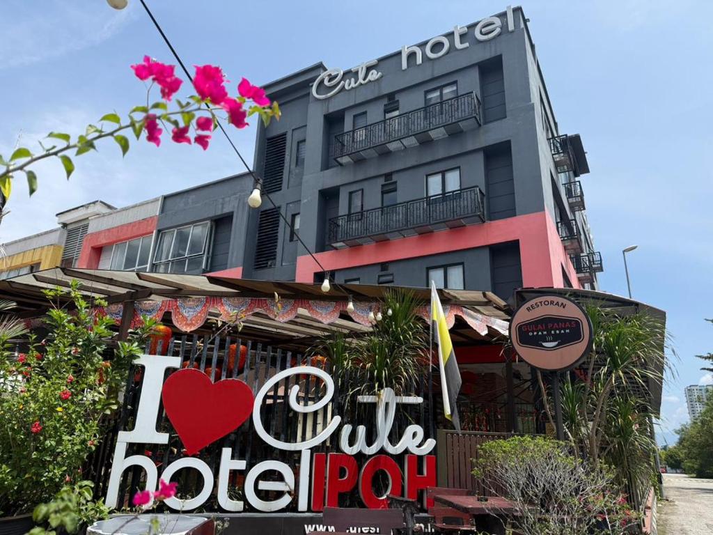 a hotel with a sign in front of a building at Cute Hotel & Dorms Ipoh in Ipoh