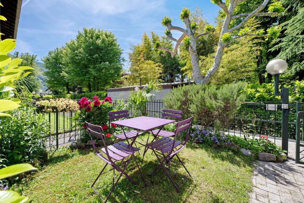 a purple table and chairs in a garden at Casa Ezia in Porlezza