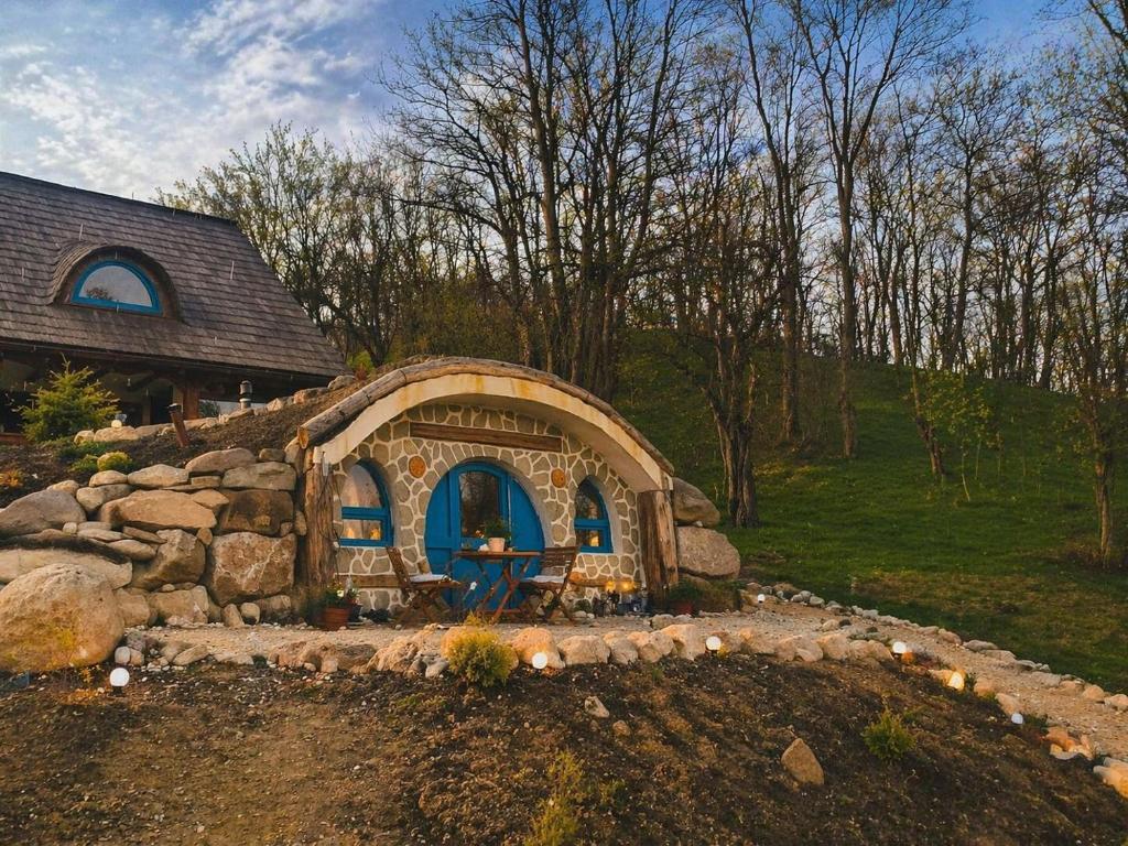a small house in a yard with a stone wall at Nook Hill in Comarnic
