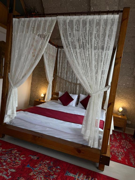 a bedroom with a canopy bed with curtains at Karballa Hotel in Aksaray