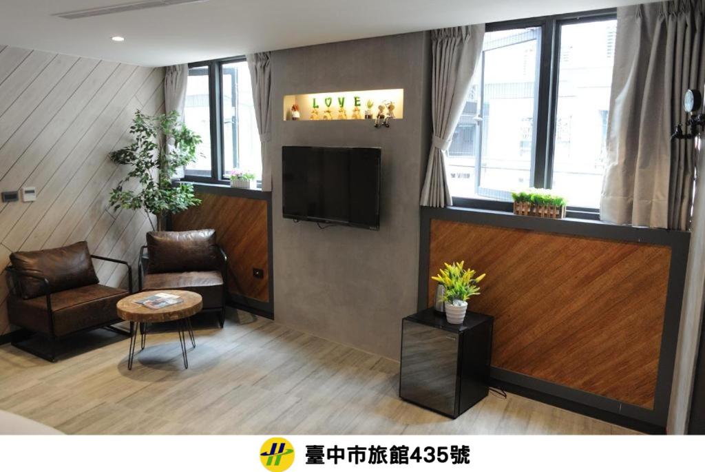 a living room with a television and a chair at K HOTEL in Taichung