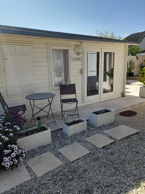 a patio with a table and chairs in front of a house at Le Chalet in Ouistreham