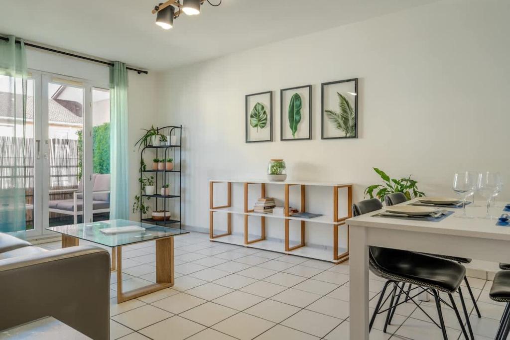 a living room with a table and some chairs at Le Jardin de l'Atrium - Appartement moderne proche de Genève et Palexpo in Saint-Julien-en-Genevois