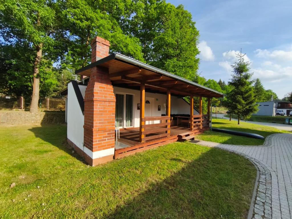 a tiny house with a porch in a park at Domek Łagów Lubuski in Łagów