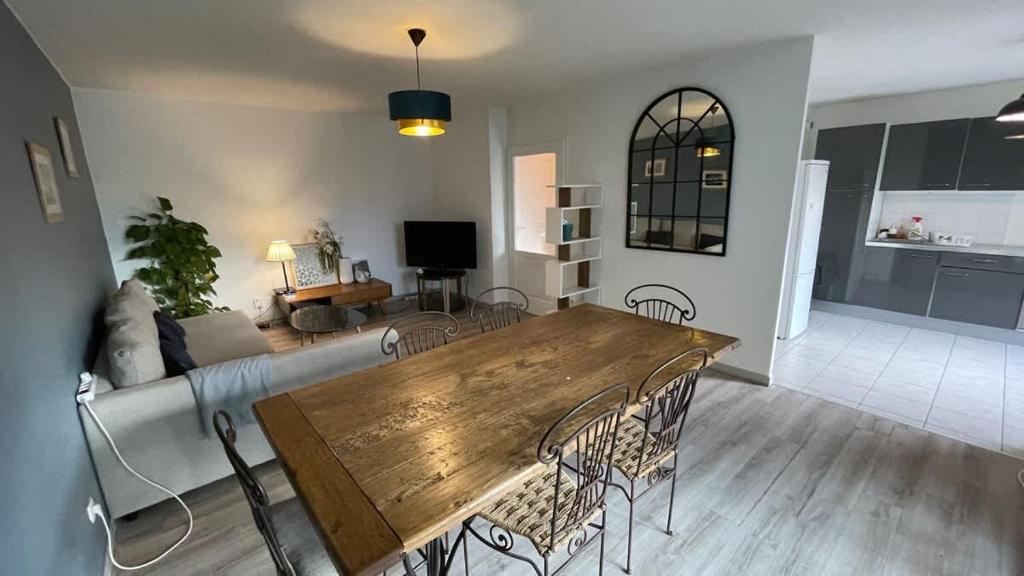 a living room with a wooden table and chairs at Le Pegan - Appartement 2 chambres proche du centre de Ferney et de Palexpo in Ferney-Voltaire