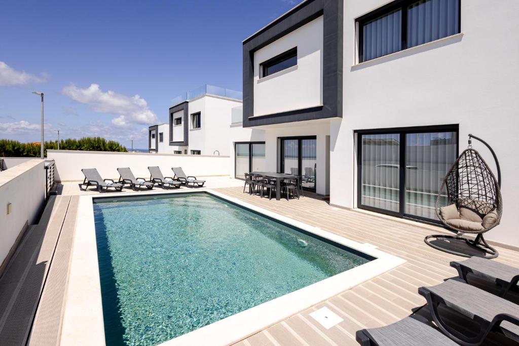 a house with a swimming pool on a deck at Villa Atlantica One Sea View - Pool - Sunset in Lourinhã