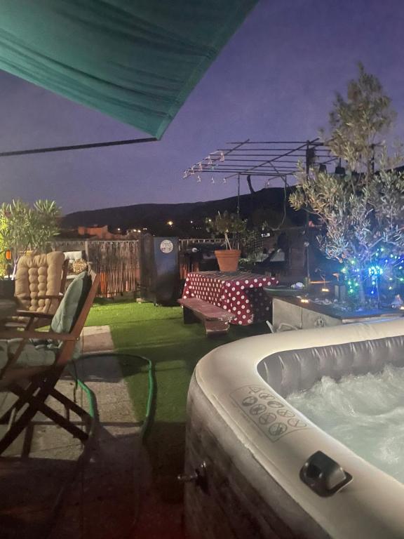 a backyard with a jacuzzi tub and a patio with lights at La Belle Vue in Ganges