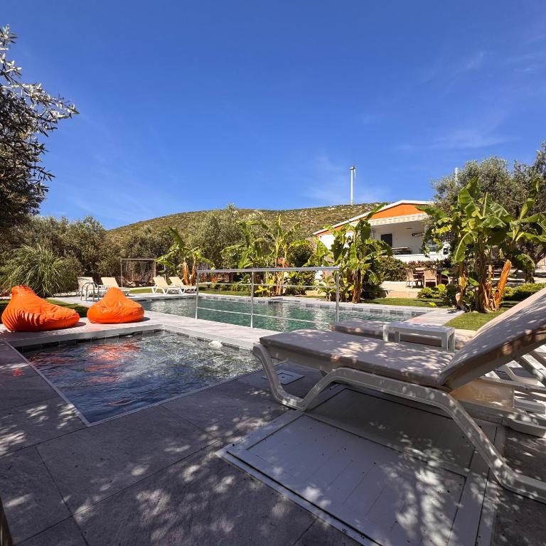a swimming pool with a chaise lounge and a swimming pool at Alaçatı Beka House in Alaçatı