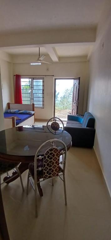 a living room with a table and a couch at Roamwander APARTMENT in Vagamon