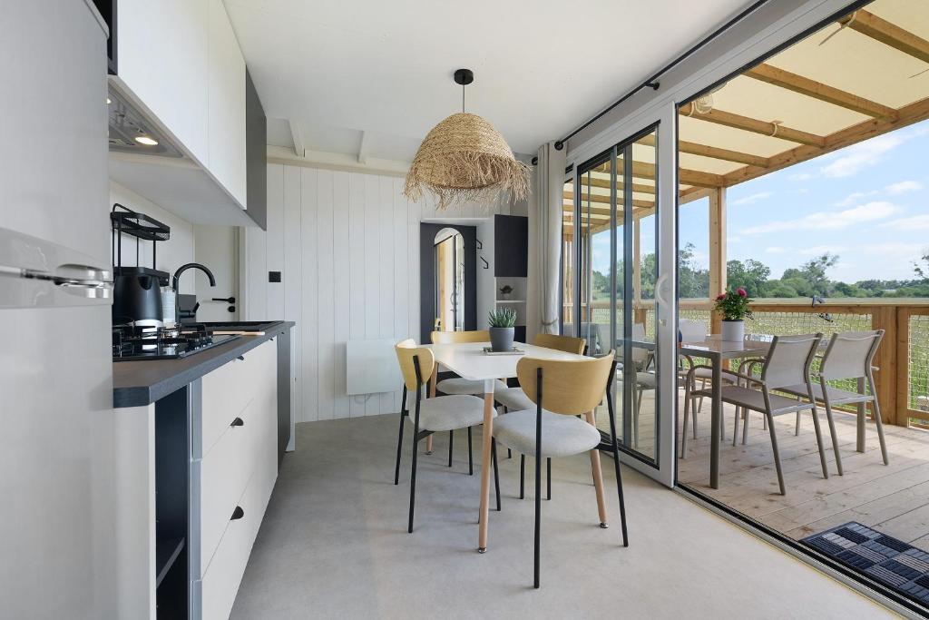 a kitchen and dining room with a table and chairs at Martinette in Saint-Pair-sur-Mer
