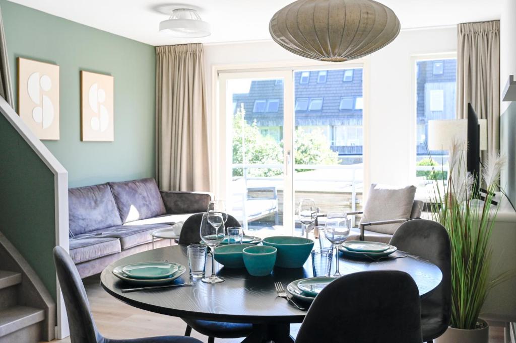 a living room with a table and a couch at Waddenhuyske in Hollum