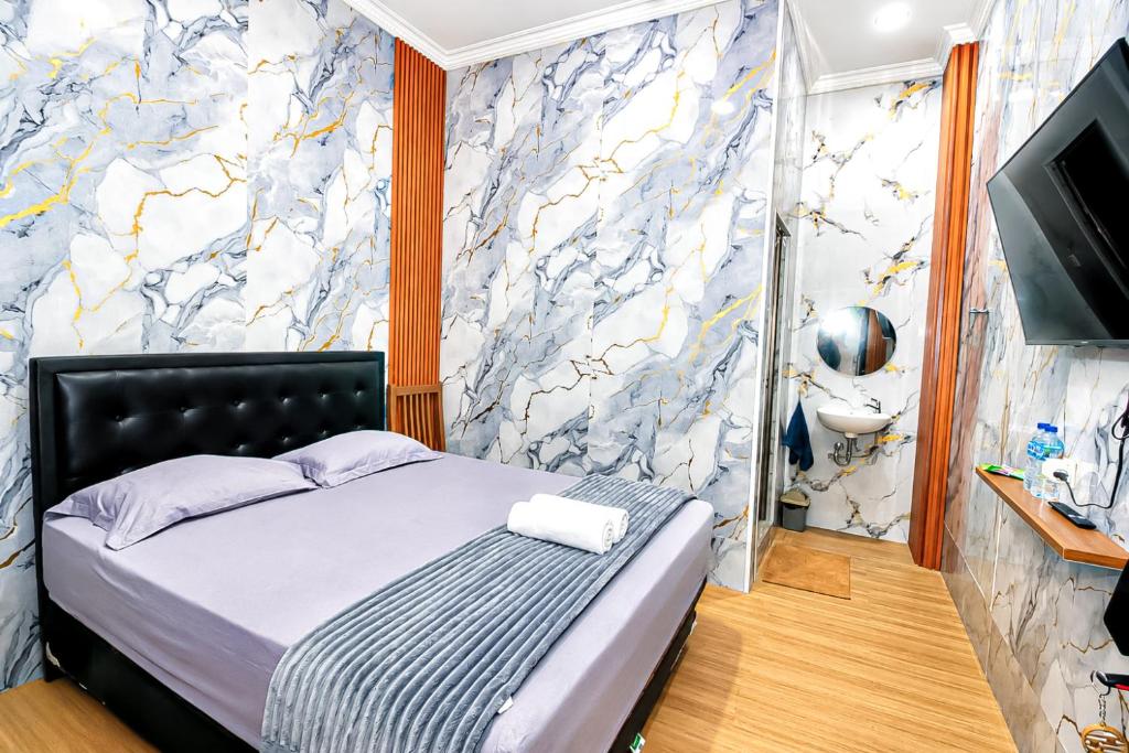 a bedroom with a bed and a wall with a mural at Lestari Malioboro Guesthouse in Sentool
