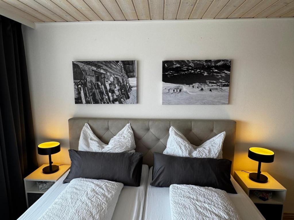 a bedroom with two beds and two pictures on the wall at Allgäuauszeit mit Bergblick - Sauna - Balkon in Scheidegg
