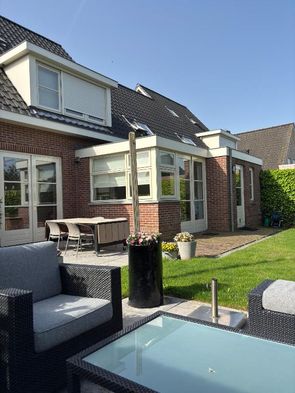 a patio with a table and chairs in front of a house at Vakantiewoning Yerseke in Yerseke
