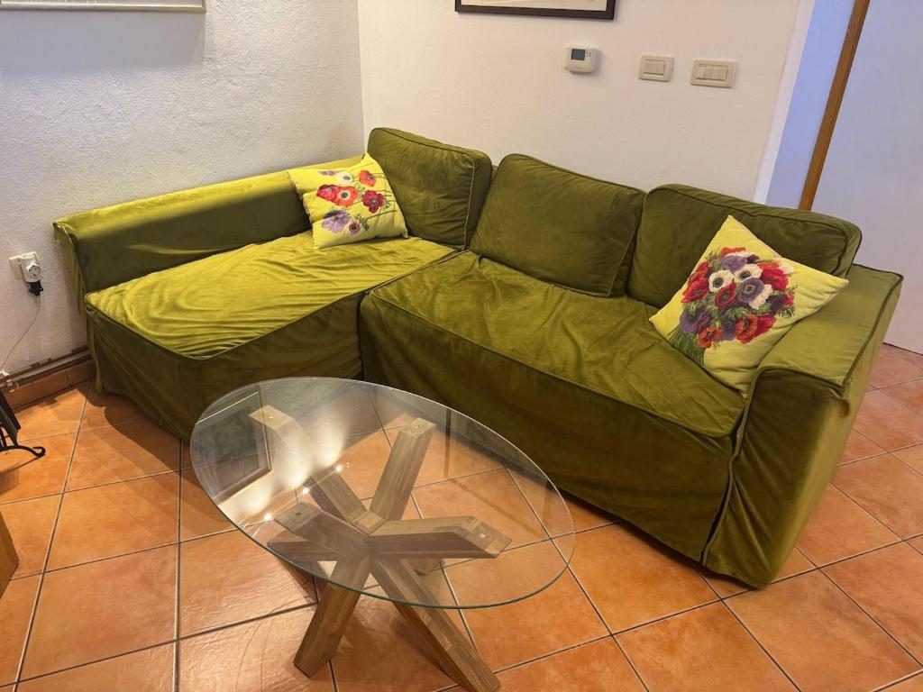 a green couch in a living room with a glass table at Istria Stone House in Marasi