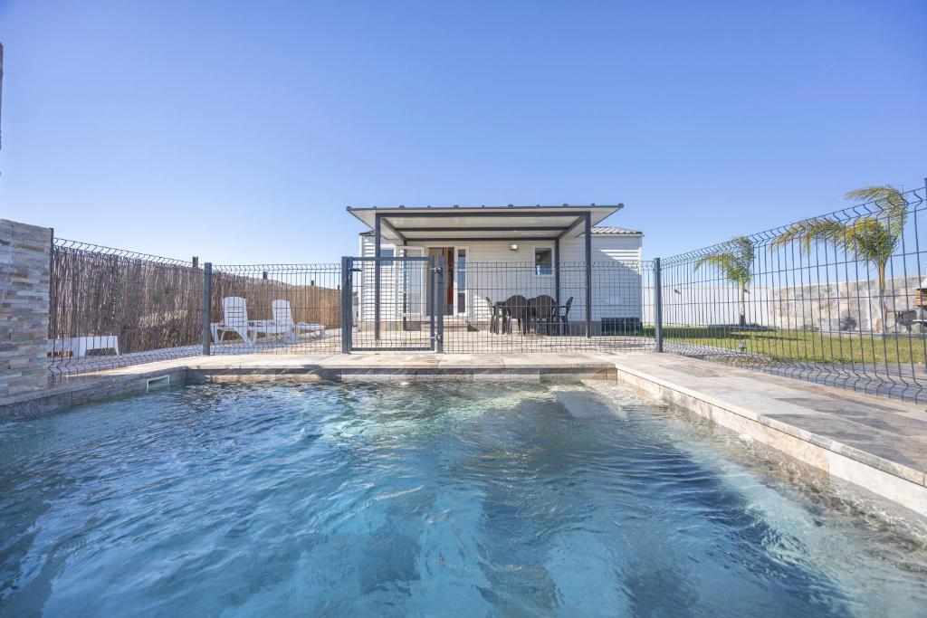 a swimming pool in a yard with a fence at Bungalow Tranquilo Cerca de Roche in Conil de la Frontera