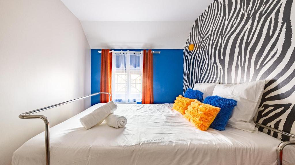 a bed with colorful pillows on it in a room at Pop Hôtel in Dijon