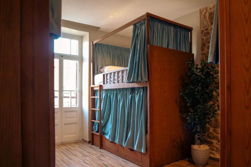 ein Zimmer mit einem Etagenbett und blauen Vorhängen in der Unterkunft StaBene Hostel in Port Said