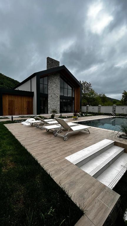 a house with a pool and some lounge chairs at escape gabala in Vǝndam