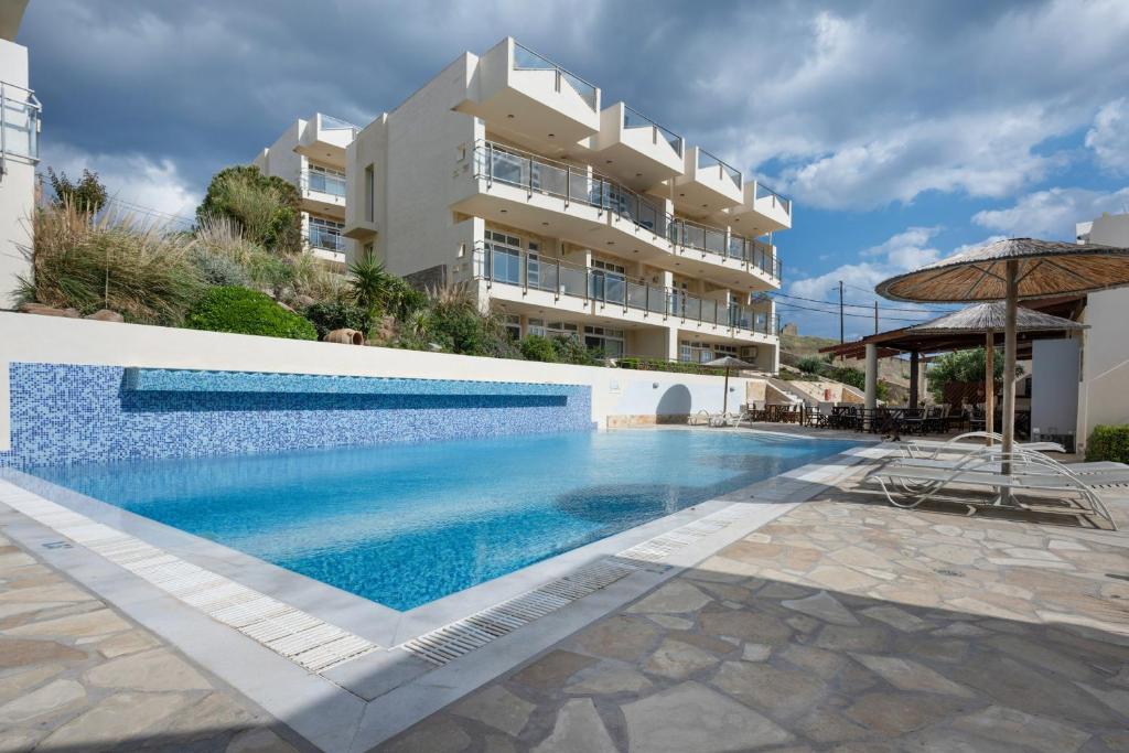 a swimming pool in front of a building at Apartment Kreta in Strandnähe in Pilalímata