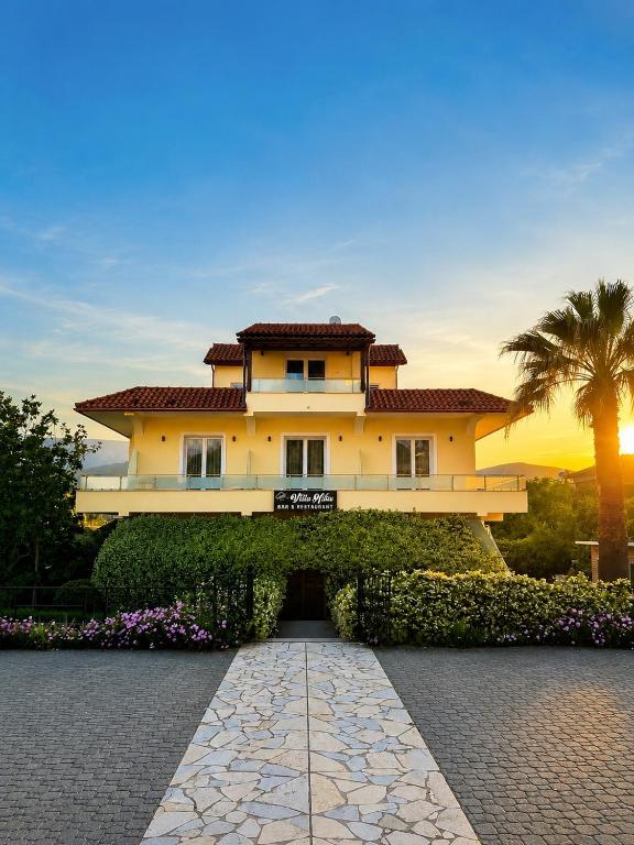 a large house with a palm tree in front of it at Villa Niku Berat in Berat