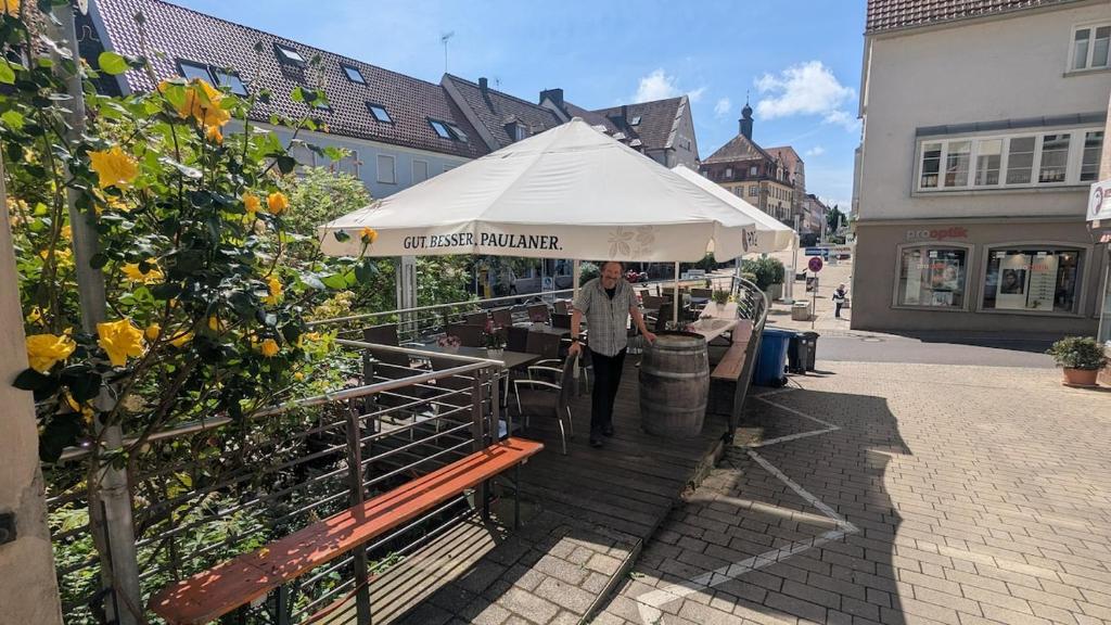 a man standing under a white umbrella on a street at Ferienwohnung Neckarsulm Mitte in Neckarsulm