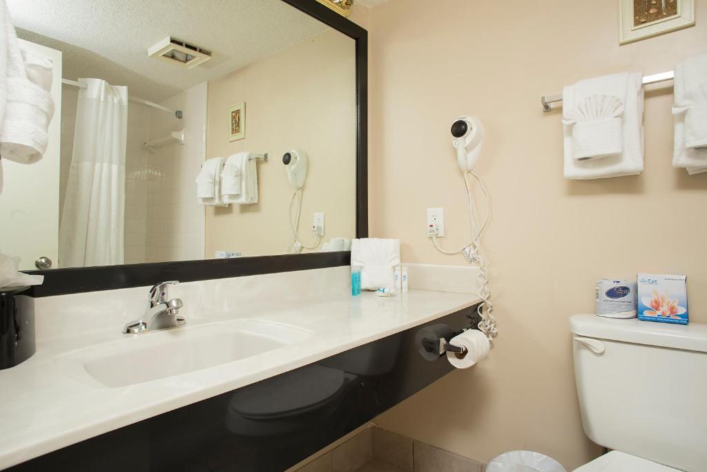 a bathroom with a sink and a mirror and a toilet at Grande Shores in Myrtle Beach