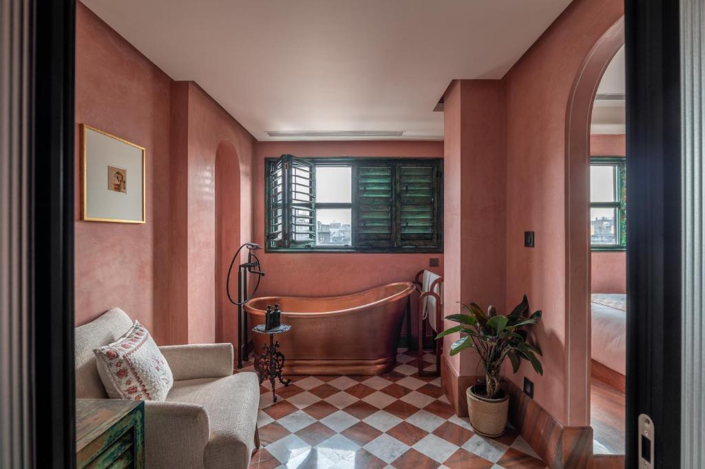a bathroom with a bath tub and a bedroom at Abode Jaipur in Jaipur