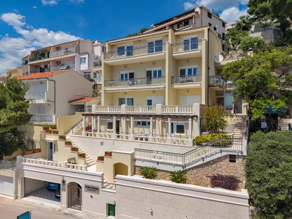 an apartment building with balconies on a hill at Villa King Apartments in Brela