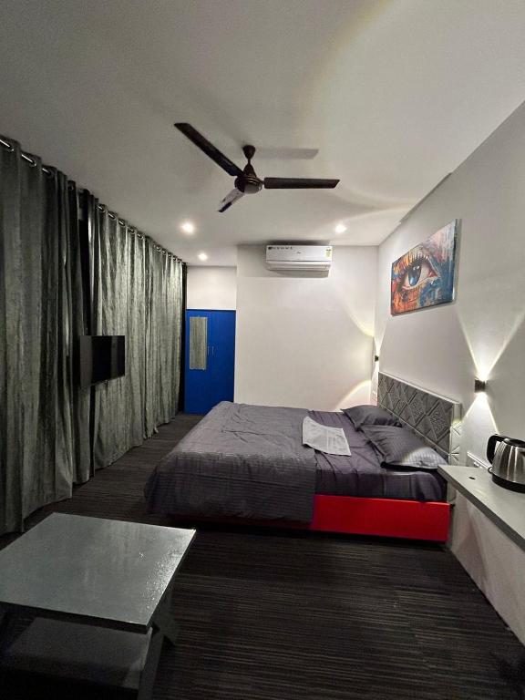 a bedroom with a bed and a ceiling fan at Restara Tower in Cochin