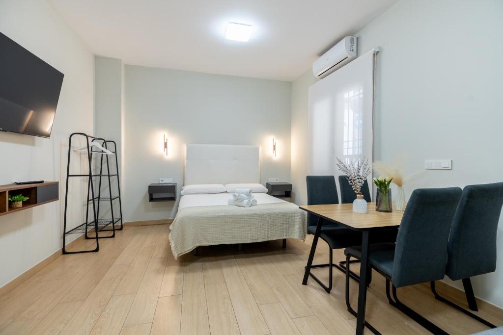 a bedroom with a bed and a table and chairs at Oasis La Corredera, En Pleno Casco Histórico in Córdoba