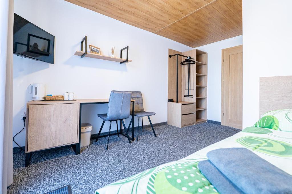 a bedroom with a bed and a desk with a chair at Pensjonat Perła in Grzybowo