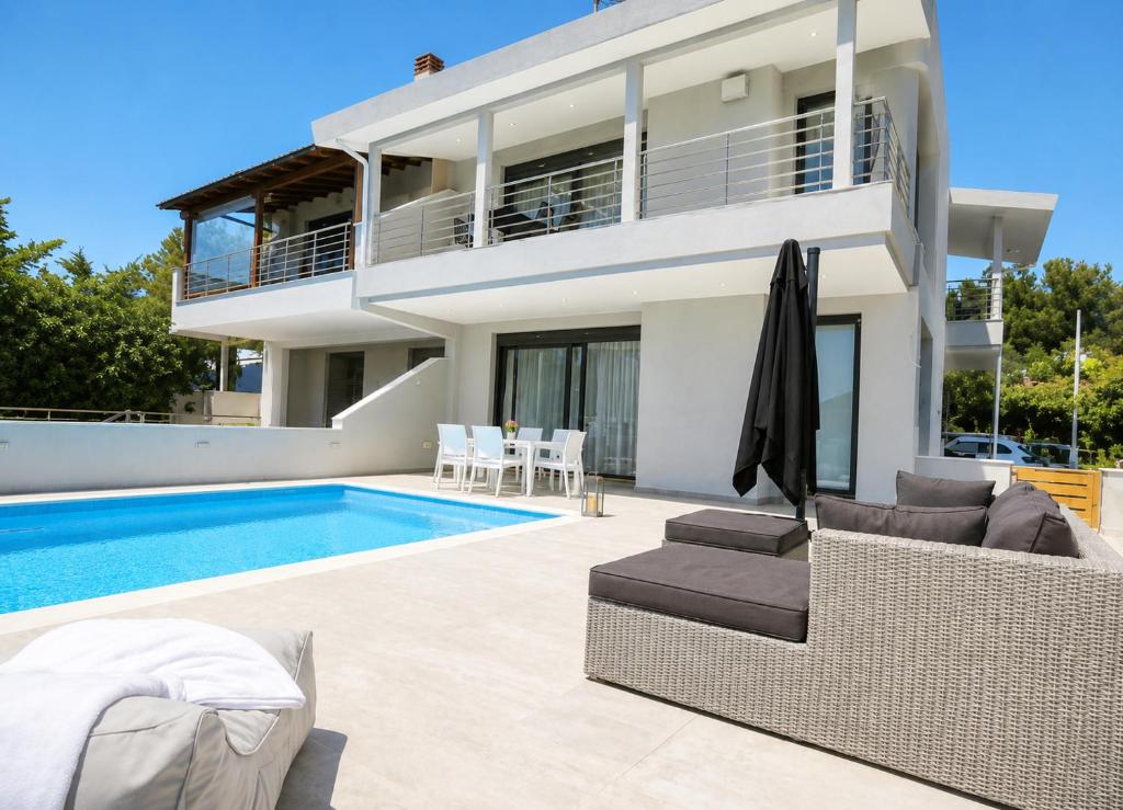 a villa with a swimming pool and a house at Heaven Horizon Villa - Ethereal and Blissful Gem in Karianí