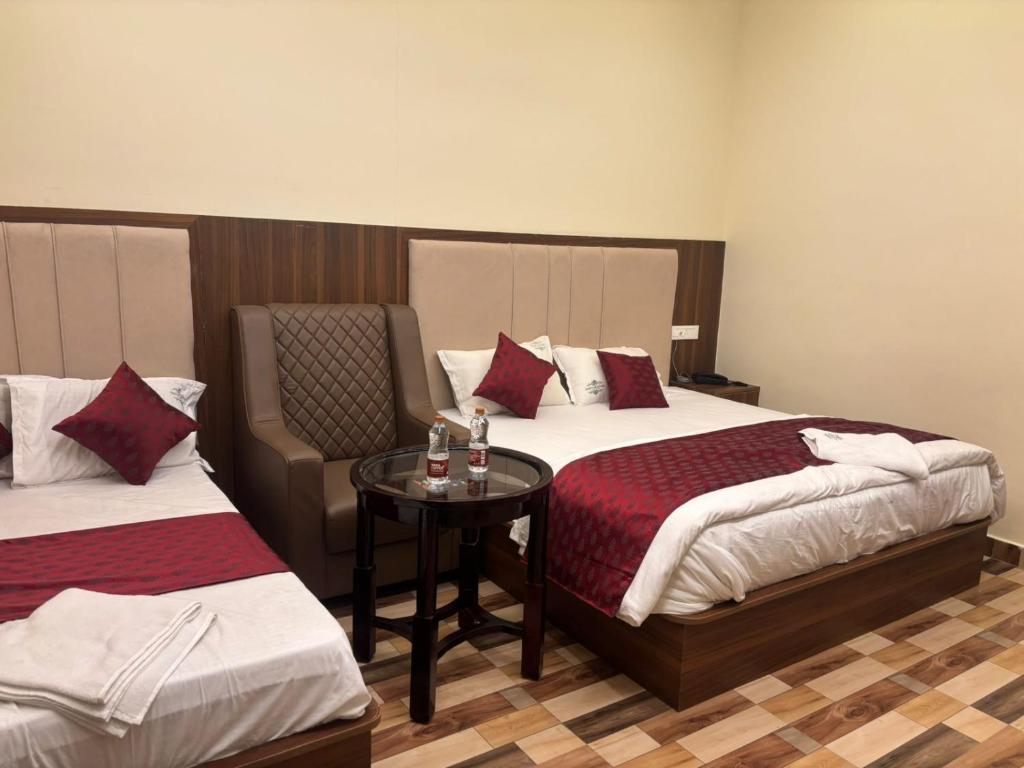 a hotel room with two beds and a chair at Hotel Gokulam Grand in Tenāli