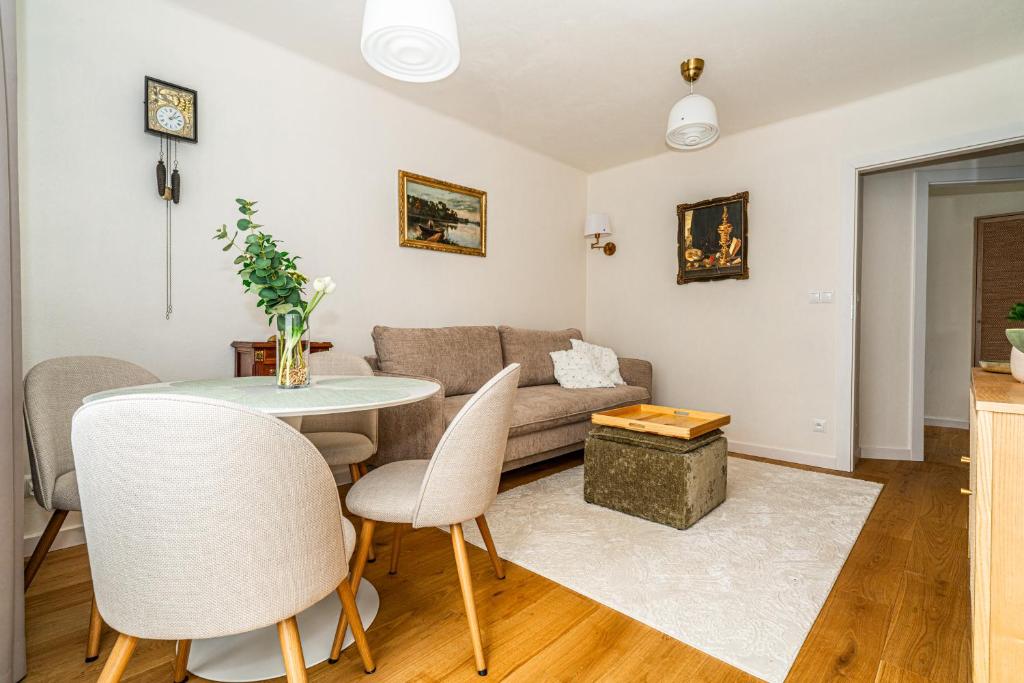 a living room with a couch and a table and chairs at Apartament Flow Tatry in Zakopane