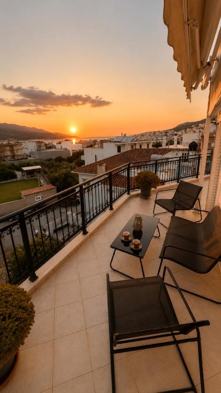 a balcony with chairs and a table and a sunset at Théa Loft Premium Sunset Sea View Escape in Vathý