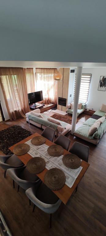 a living room with a wooden table and chairs at Verde viu in Greşu
