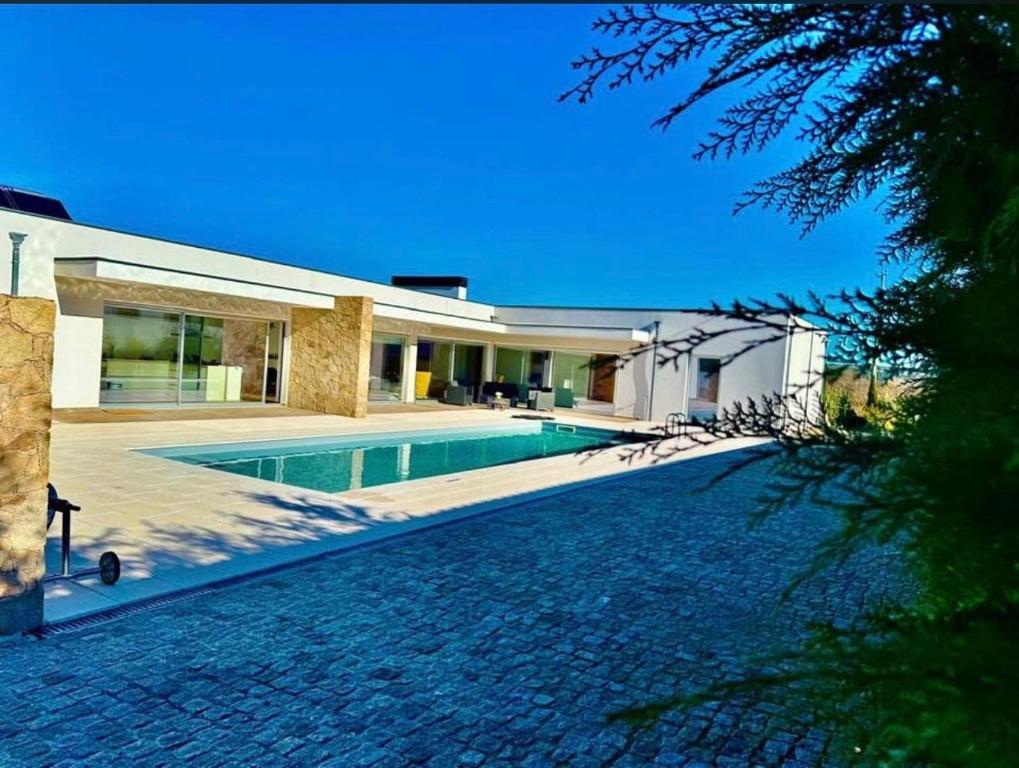 a house with a swimming pool in front of it at Quinta Chão do Ribeiro in Carvalhal