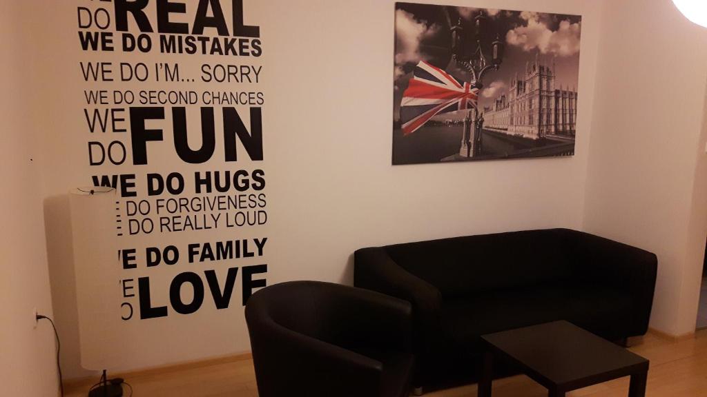 uma sala de estar com uma cadeira e cartazes na parede em Apartament Centrum em Szczecinek