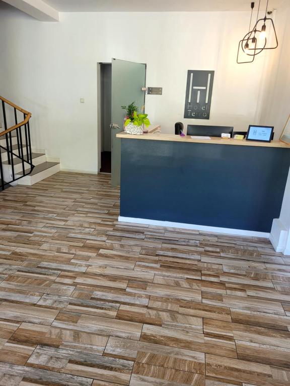 an office lobby with a blue counter and wooden floors at Hotel Terra in Oradea