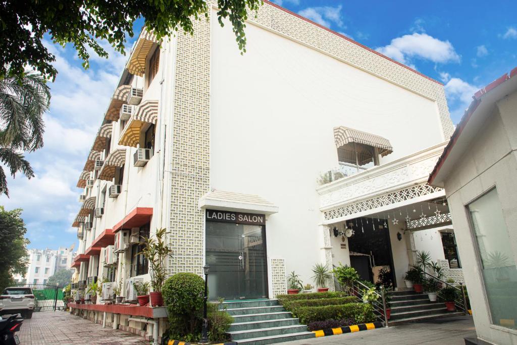 a white building with stairs in front of it at Hotel Angel in Greater Noida