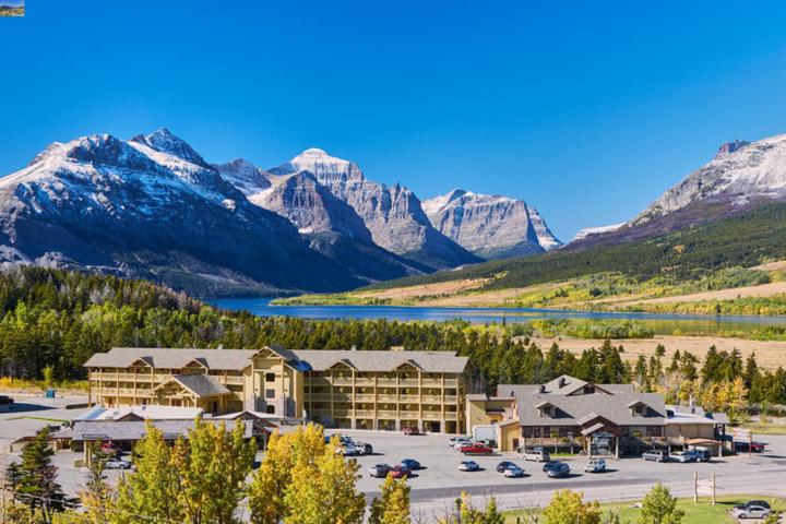 un hotel con aparcamiento frente a una montaña en St. Mary Village en Saint Mary