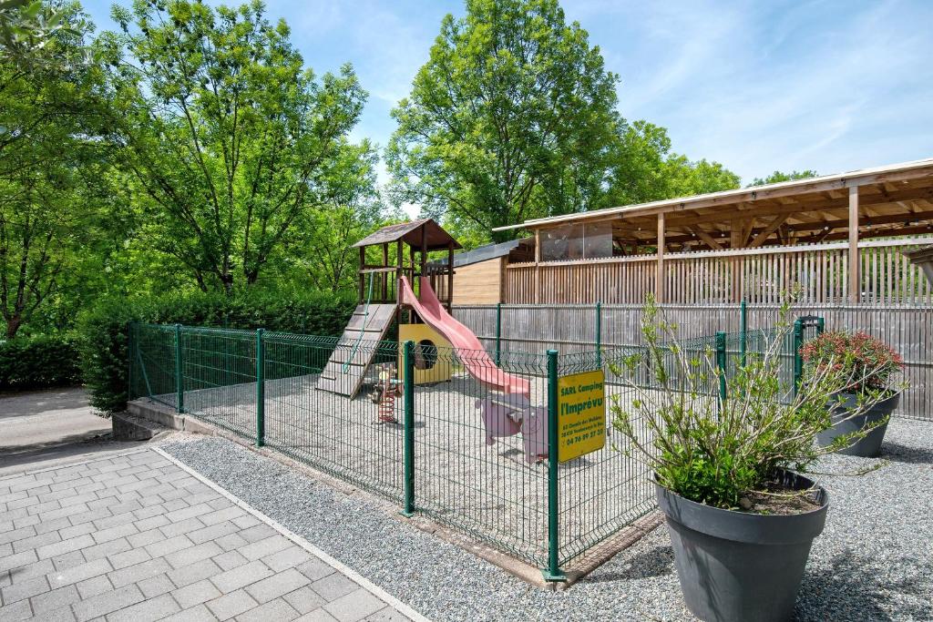 a playground with a slide in front of a building at Camping L'imprévu in Vaulnaveys-le-Bas