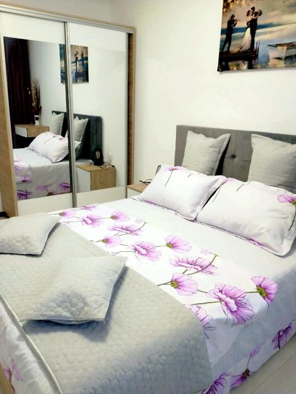 a bedroom with a large bed with flowers on it at Cazare Herculane in Băile Herculane