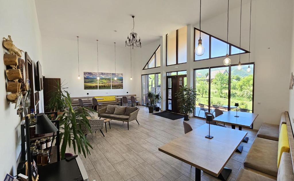 a living room with tables and chairs and windows at Cabana Chalet Transylvania in Orlat