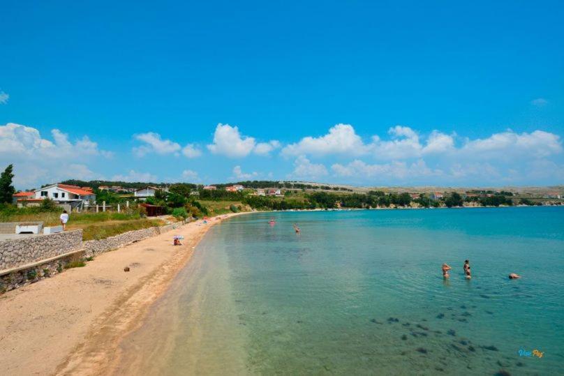 a beach with people swimming in the water at Apatmani Čriček in Vlašići