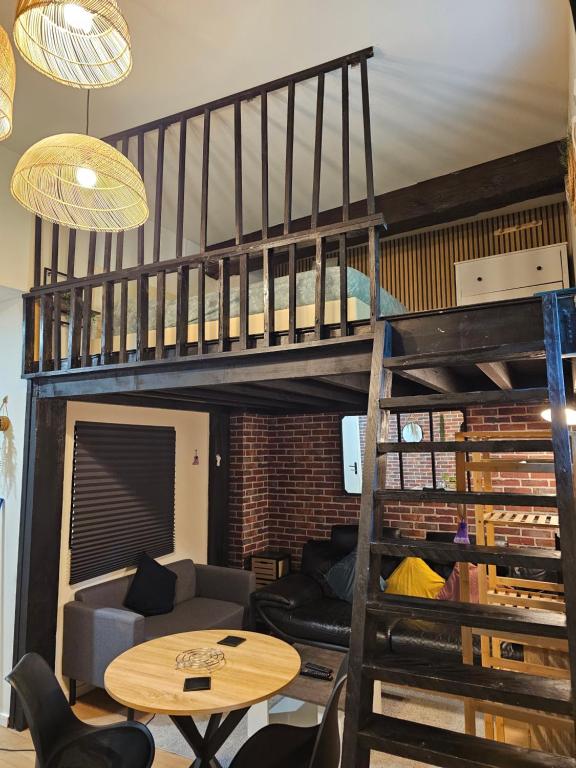a living room with a loft bed and a table at Duplex à 15 min à pieds de la gare, centre historique Montluçon in Montluçon