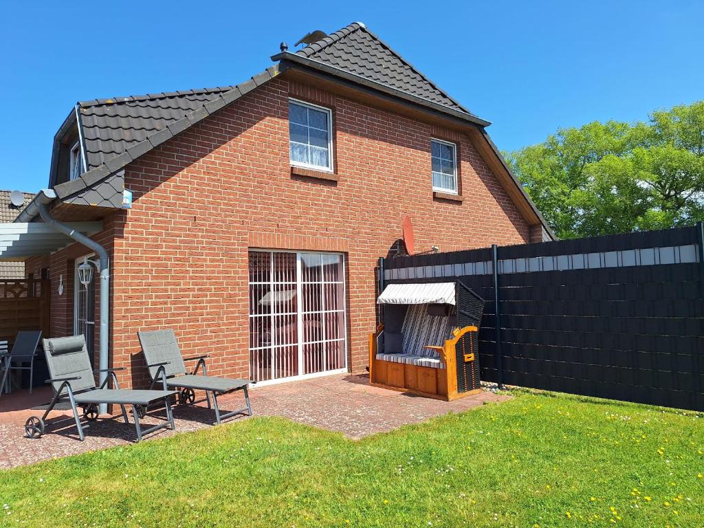 a brick house with two chairs and a table at Medemstern I in Otterndorf