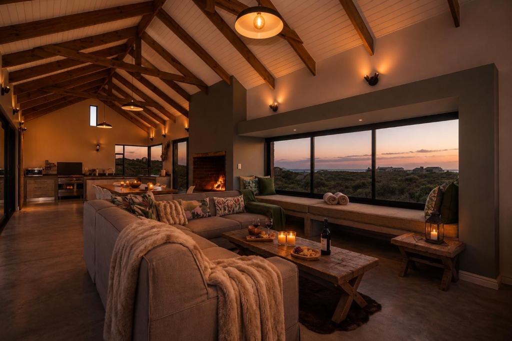 a living room with couches and a large window at Cast Away at Romansbaai - Salted Fynbos Staying in Gansbaai